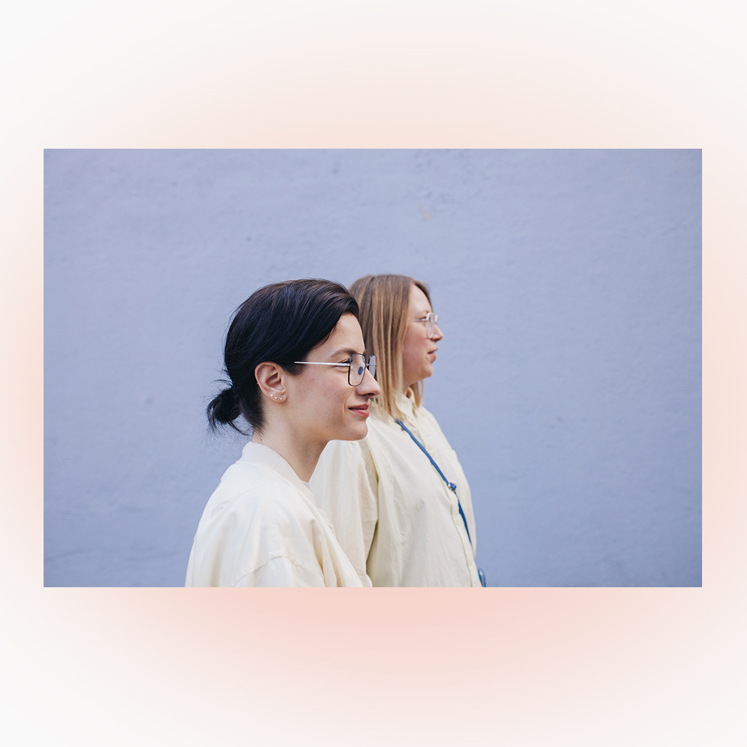 Bild von Jules & Mel seitlich stehend auf weißem Hintergrund mit rosa Blur