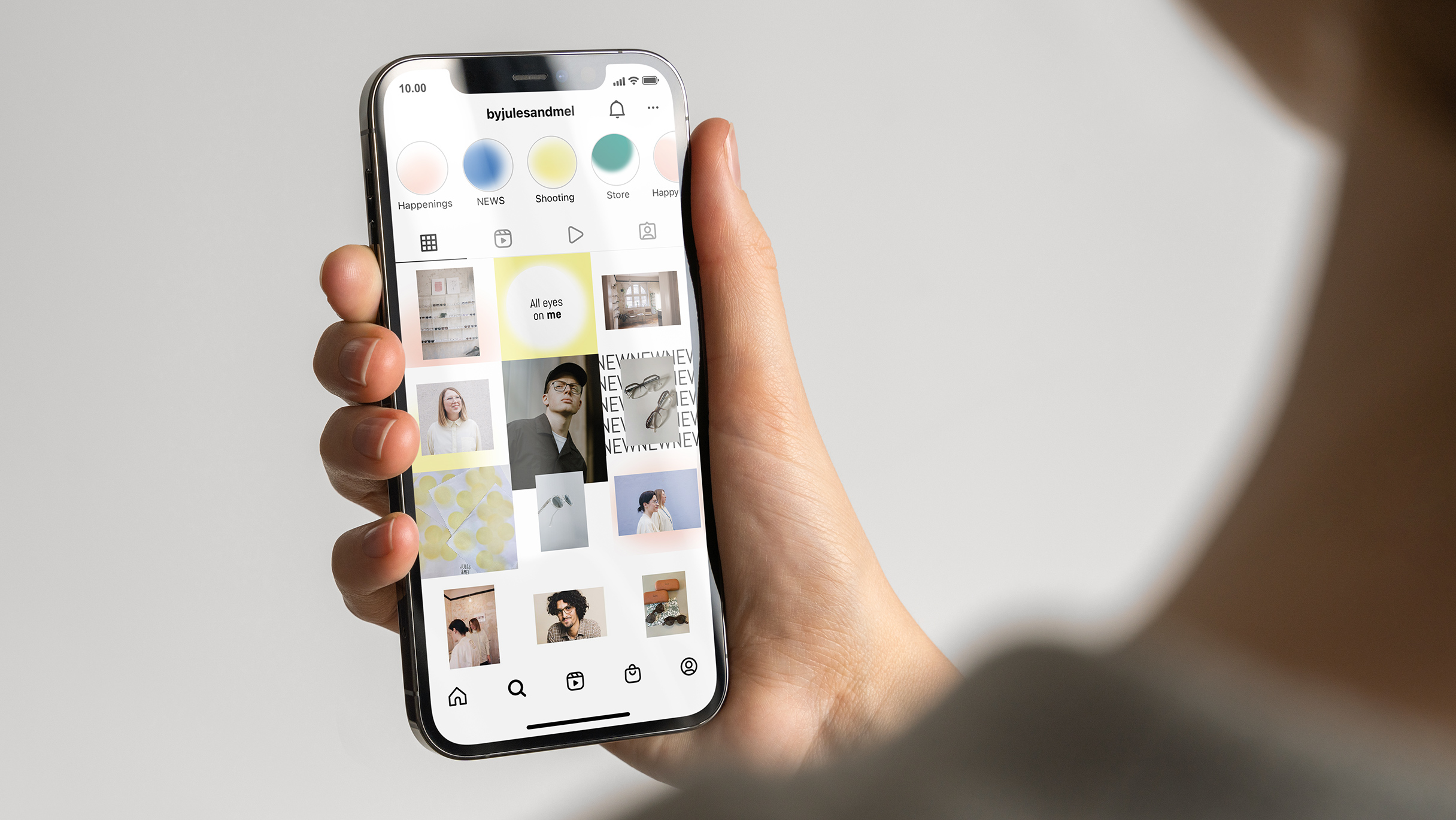Frau hält iPhone mit dem Jules & Mel Insta Feed auf dem Display