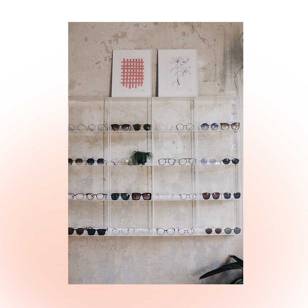 Jules & Mel Insta Post: Bild von Brillen in Regal auf weißem Hintergrund mit rosa Blur